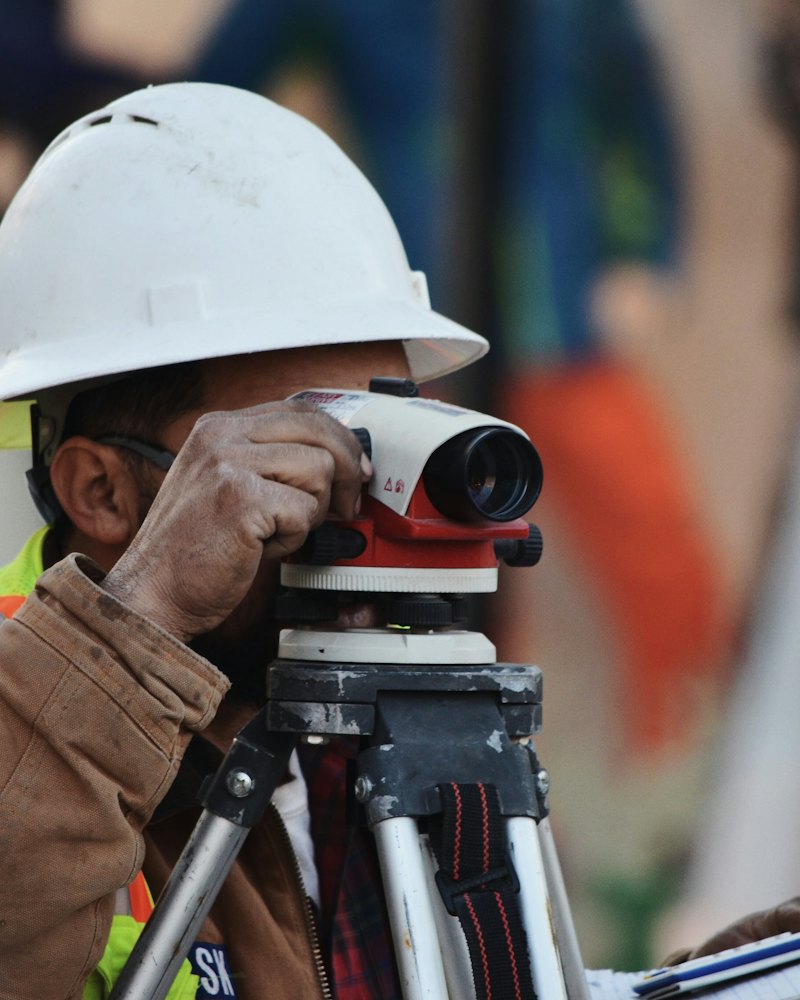Topógrafo realizando control de niveles en obra